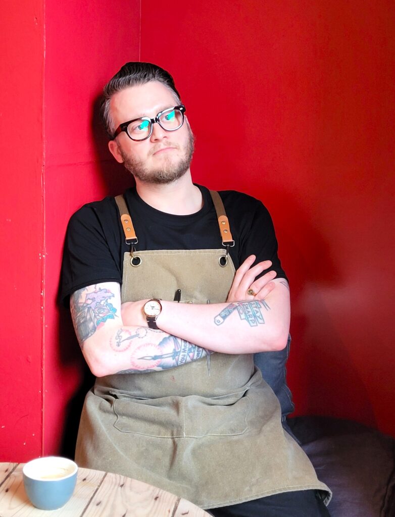 Portrait of Euan in the cafe, gazing into the distance